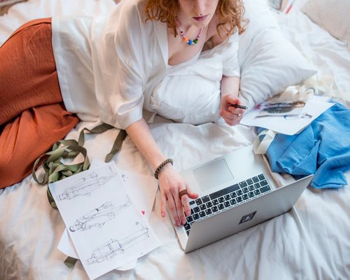 Modern designer workspace with laptop and sketches